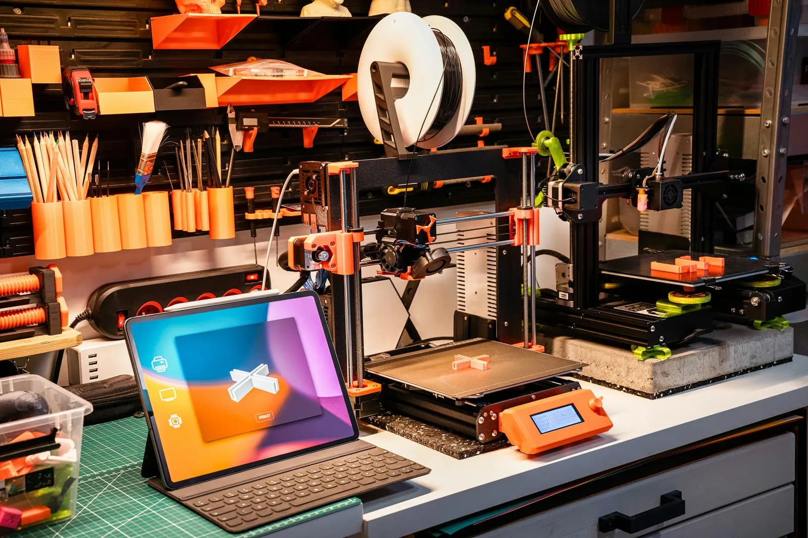 3D printing workbench with printers, tools and a tablet